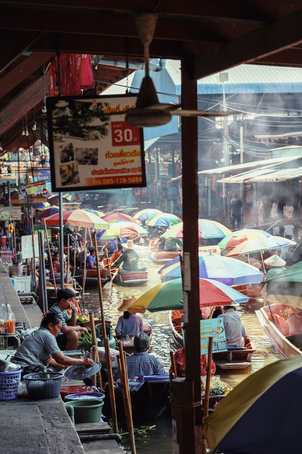 a group of people sitting under umbrellas in a market