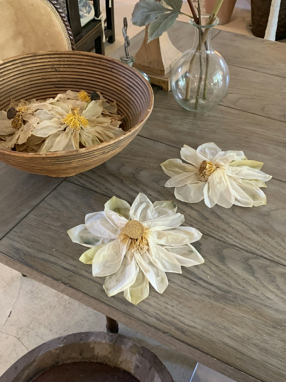 a wooden table topped with a basket filled with flowers