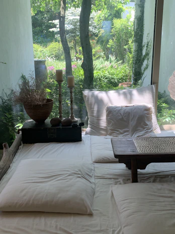 a bed with a white comforter and pillows