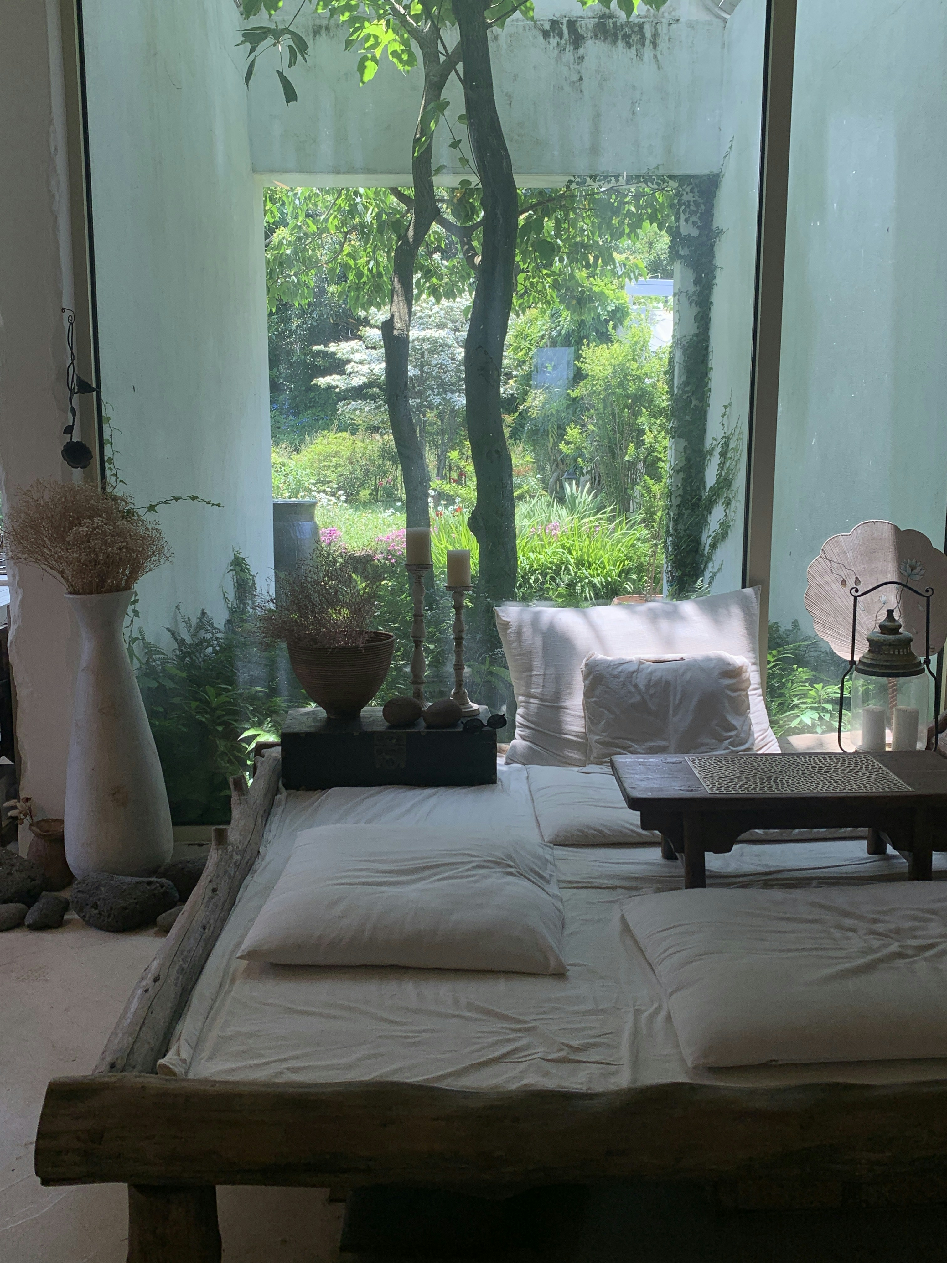 kamar dengan jendela besar dan tempat tidur dengan seprai putih