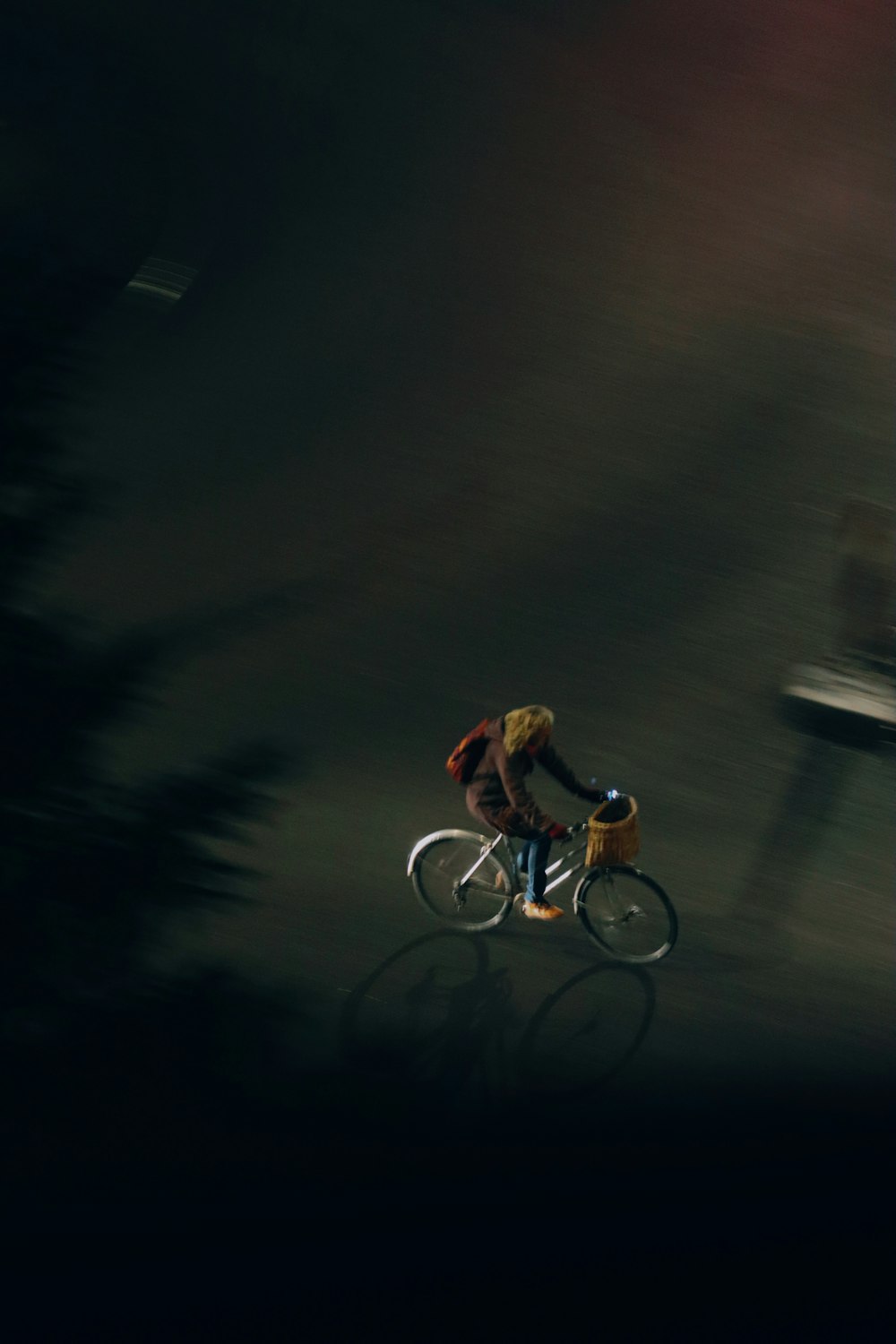 a man riding a bike down a street at night