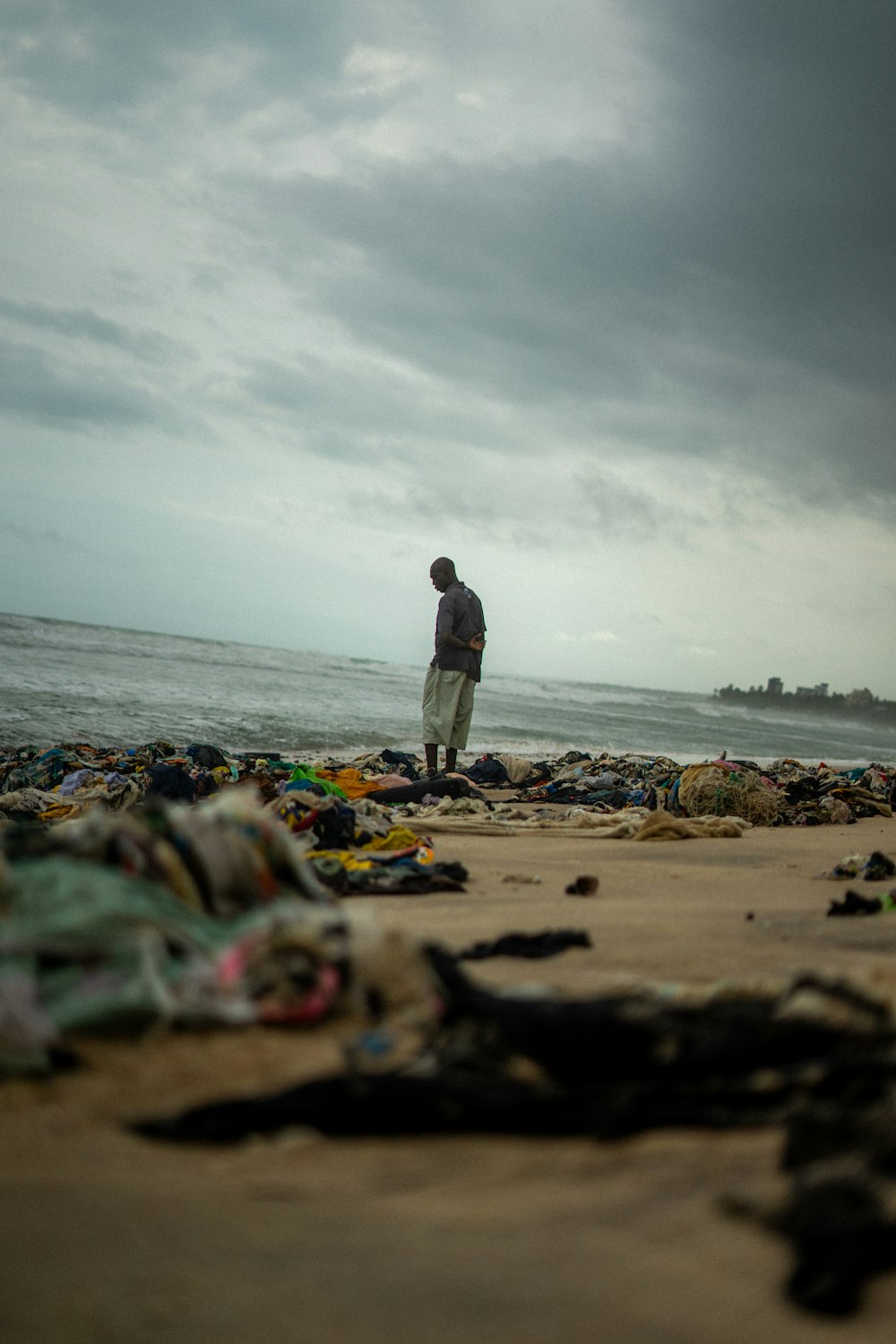 a man standing on top of a sandy beach next to the ocean