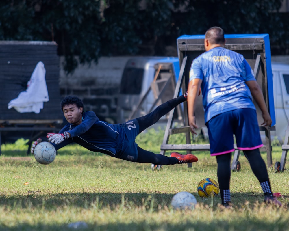 a man diving for a soccer ball on a field