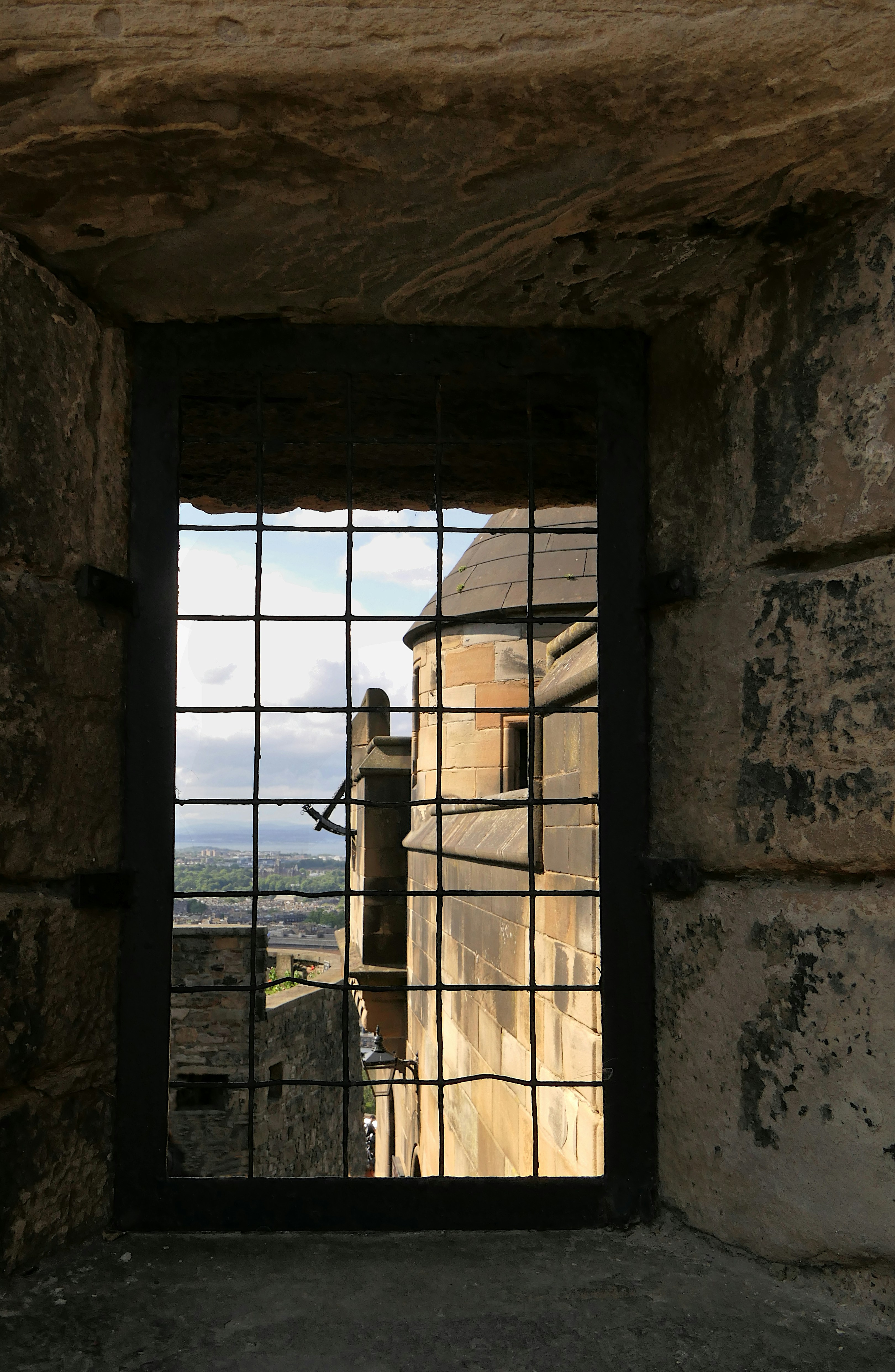 a window in a stone wall with bars on it