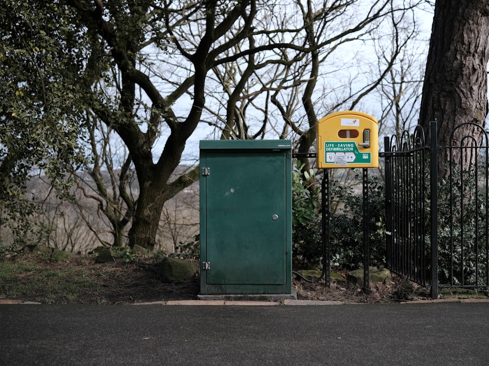 a green box sitting on the side of a road