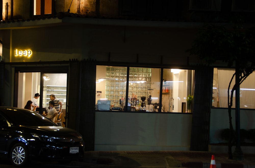 a car parked in front of a store at night