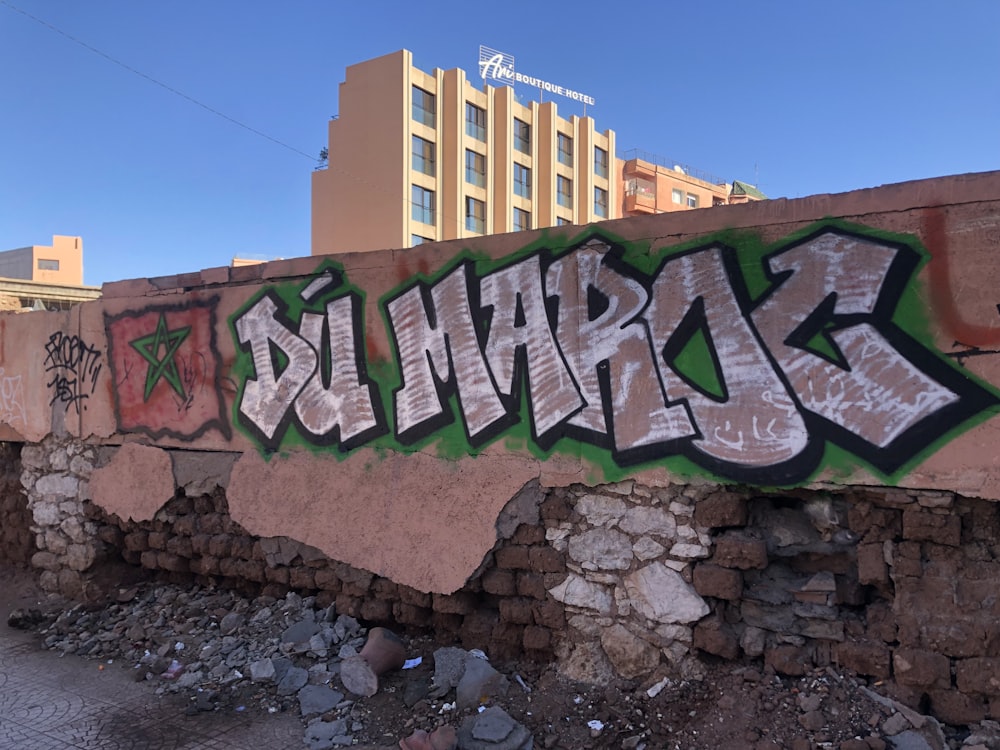 a wall covered in graffiti next to a building