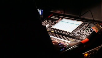 a sound mixing console in a dark room