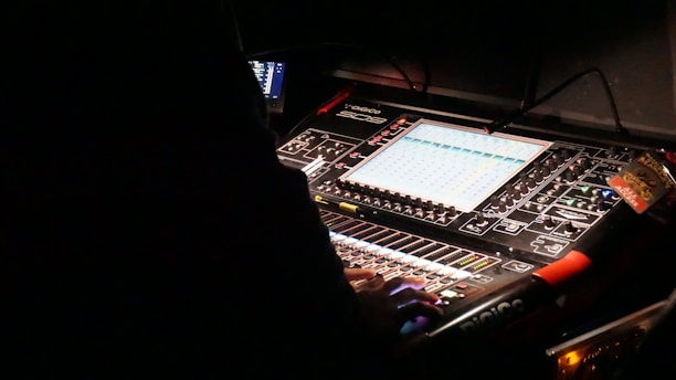 a sound mixing console in a dark room