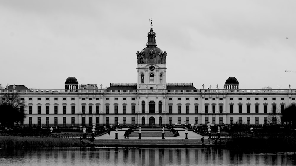 a large building with a clock tower next to a body of water