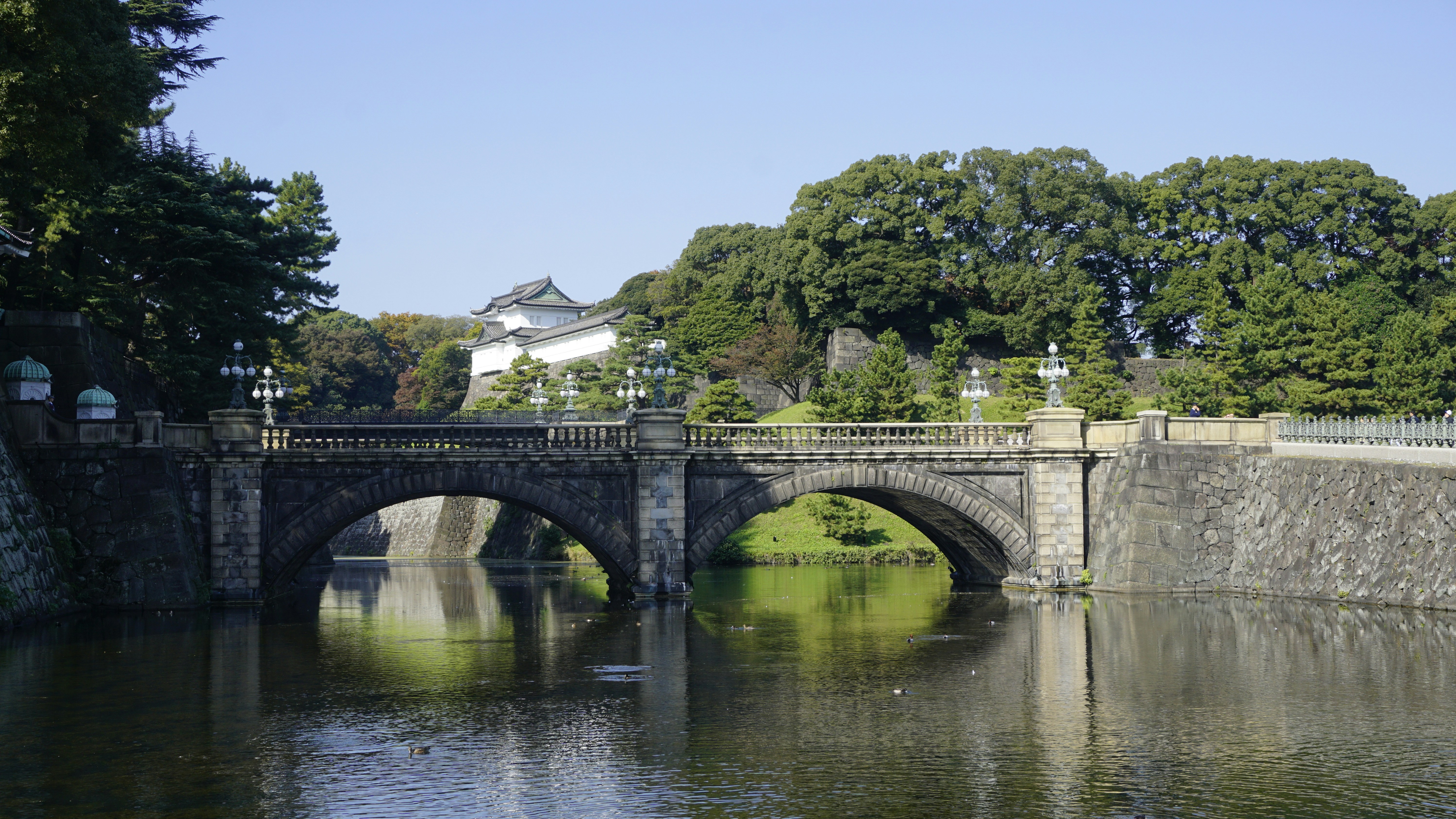 a bridge over a body of water with a building in the background