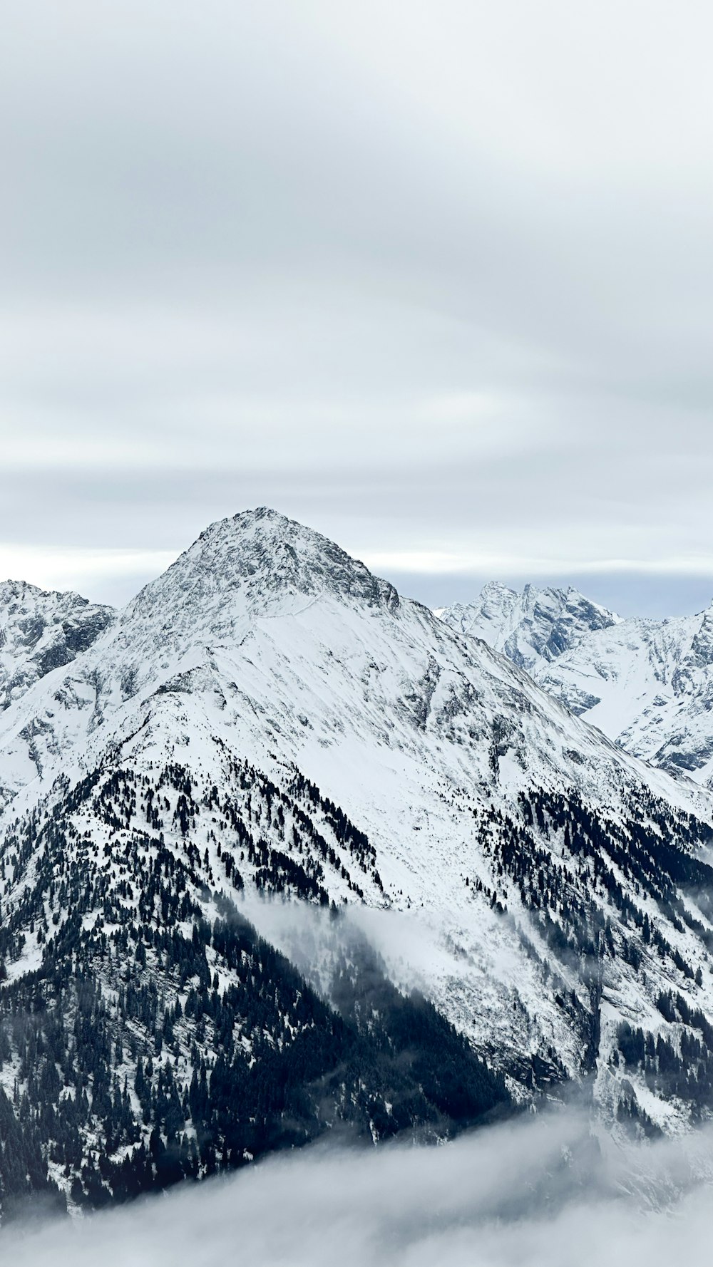 a mountain range covered in snow and clouds