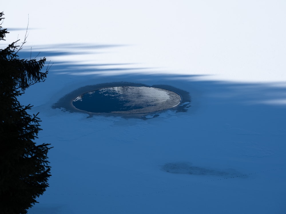 a snow covered ground with a hole in the middle