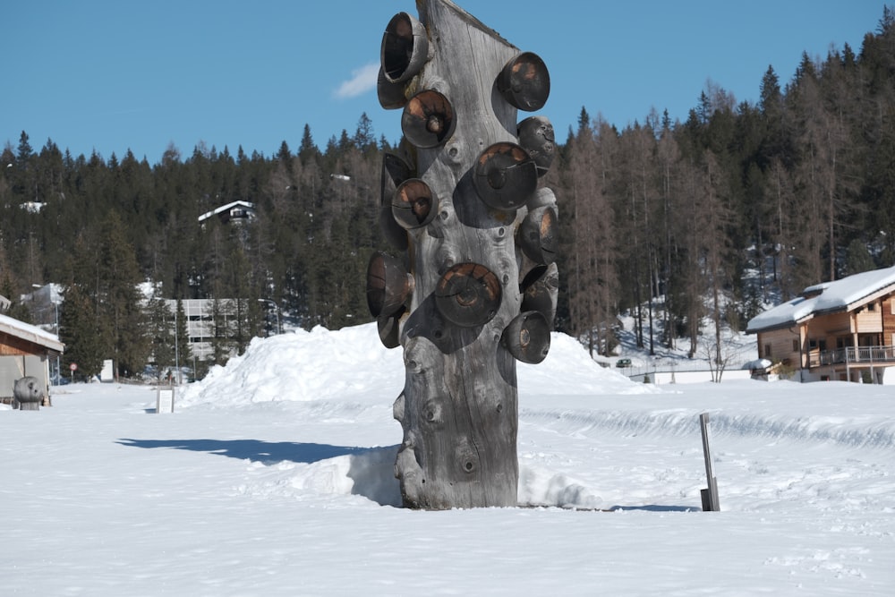 a wooden sculpture in the middle of a snowy field