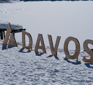 a wooden sign that reads davos in the snow