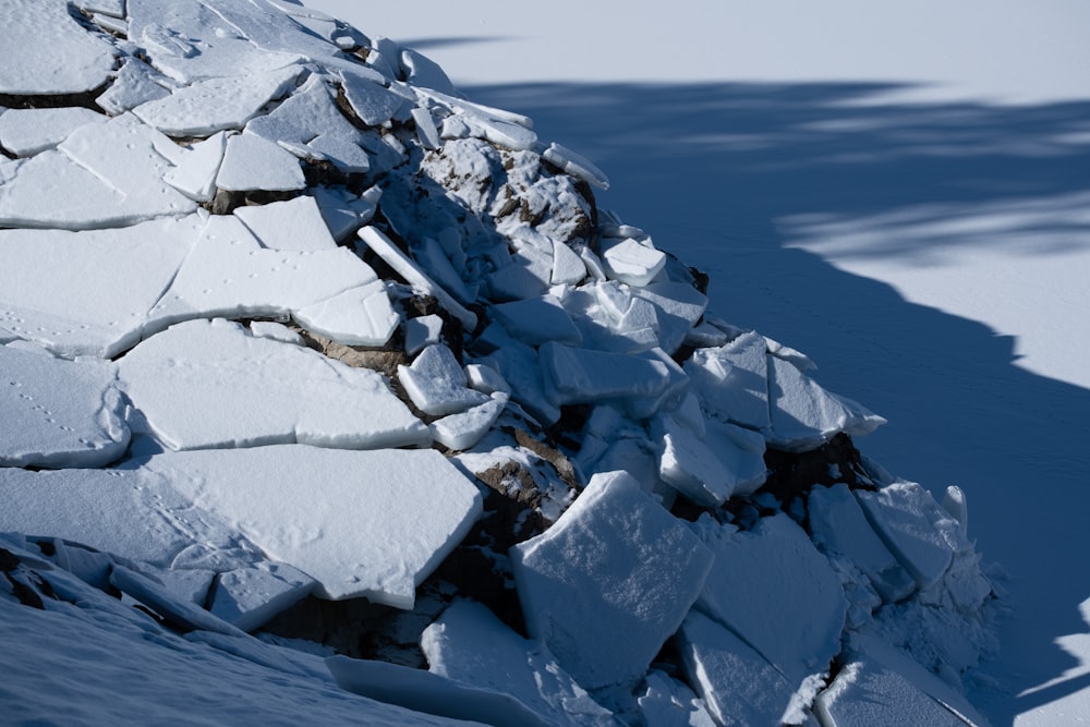 a pile of ice blocks sitting on top of a snow covered slope