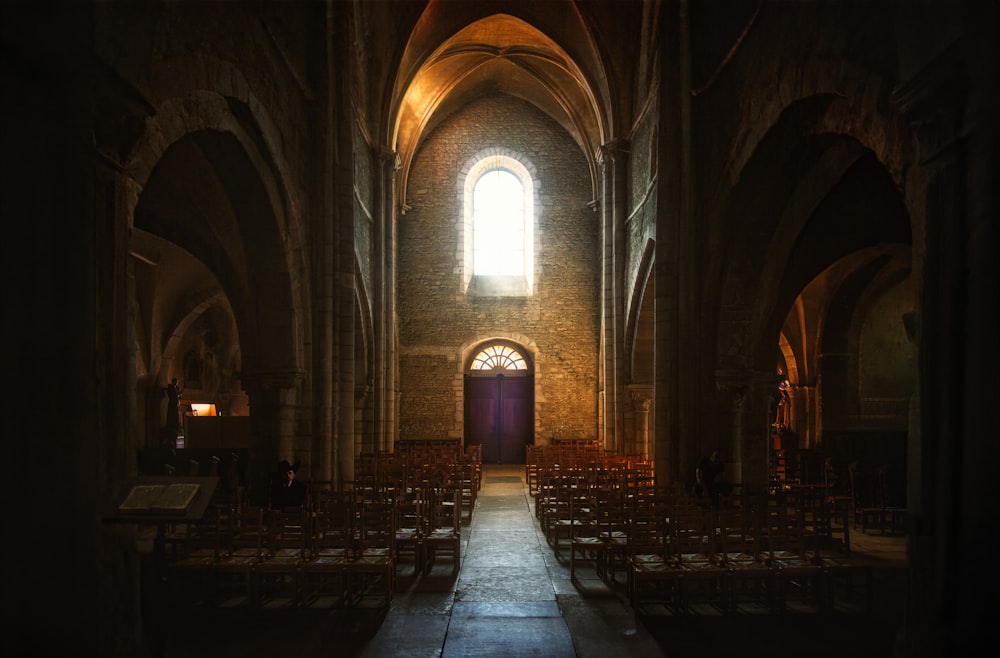 a dimly lit church with rows of chairs