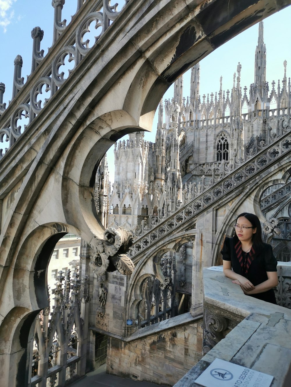 a woman is sitting on a ledge in front of a building