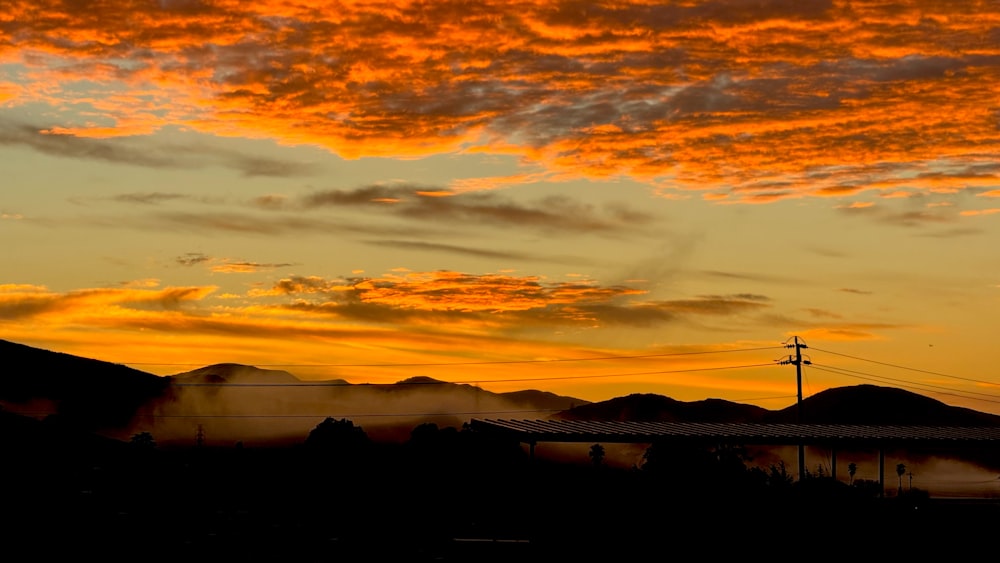 a view of the sky at sunset with mountains in the background