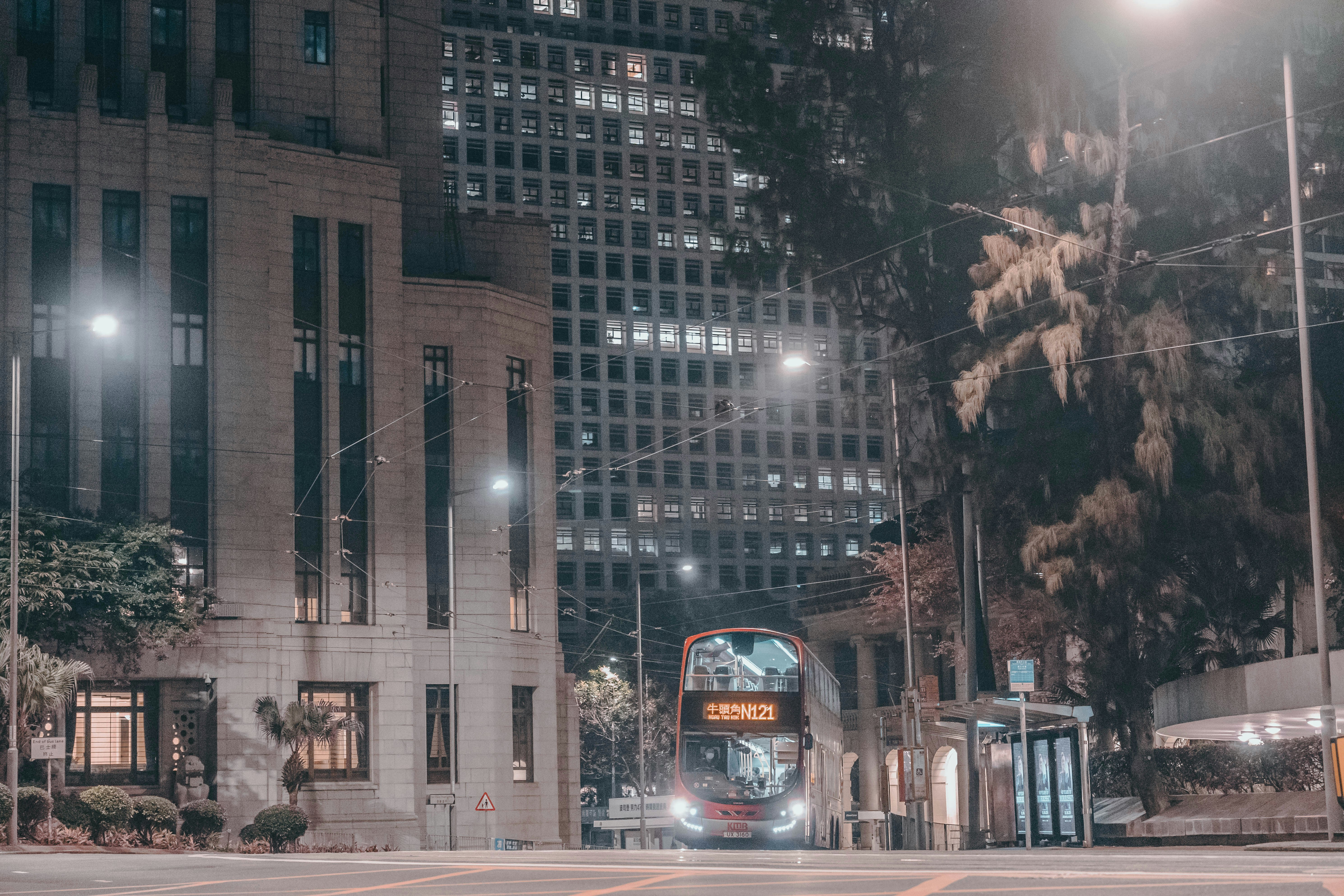 a double decker bus driving down a street at night