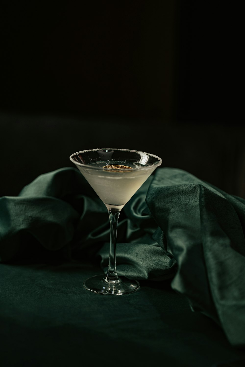 a martini sitting on top of a table next to a green cloth