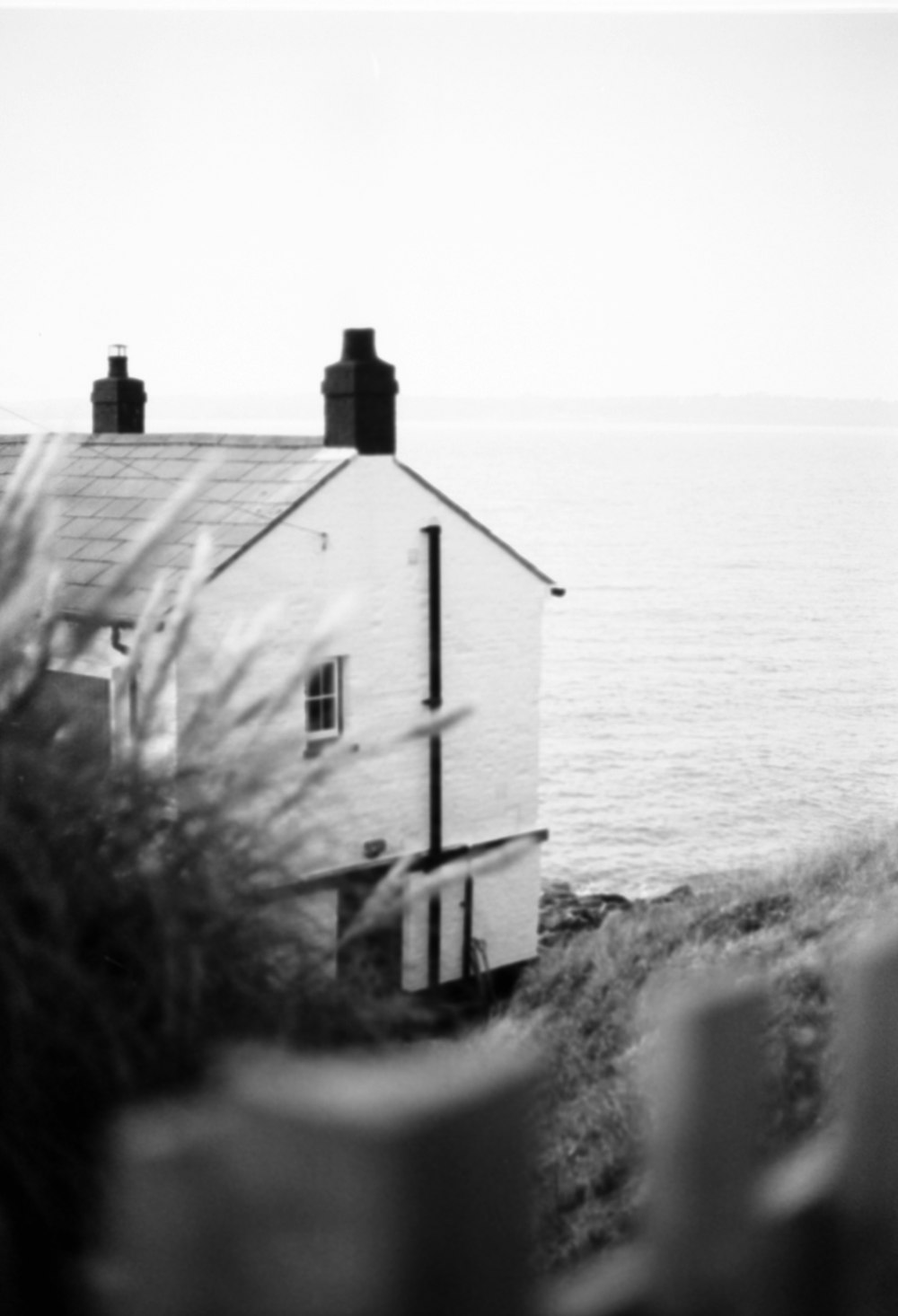 a black and white photo of a house by the ocean