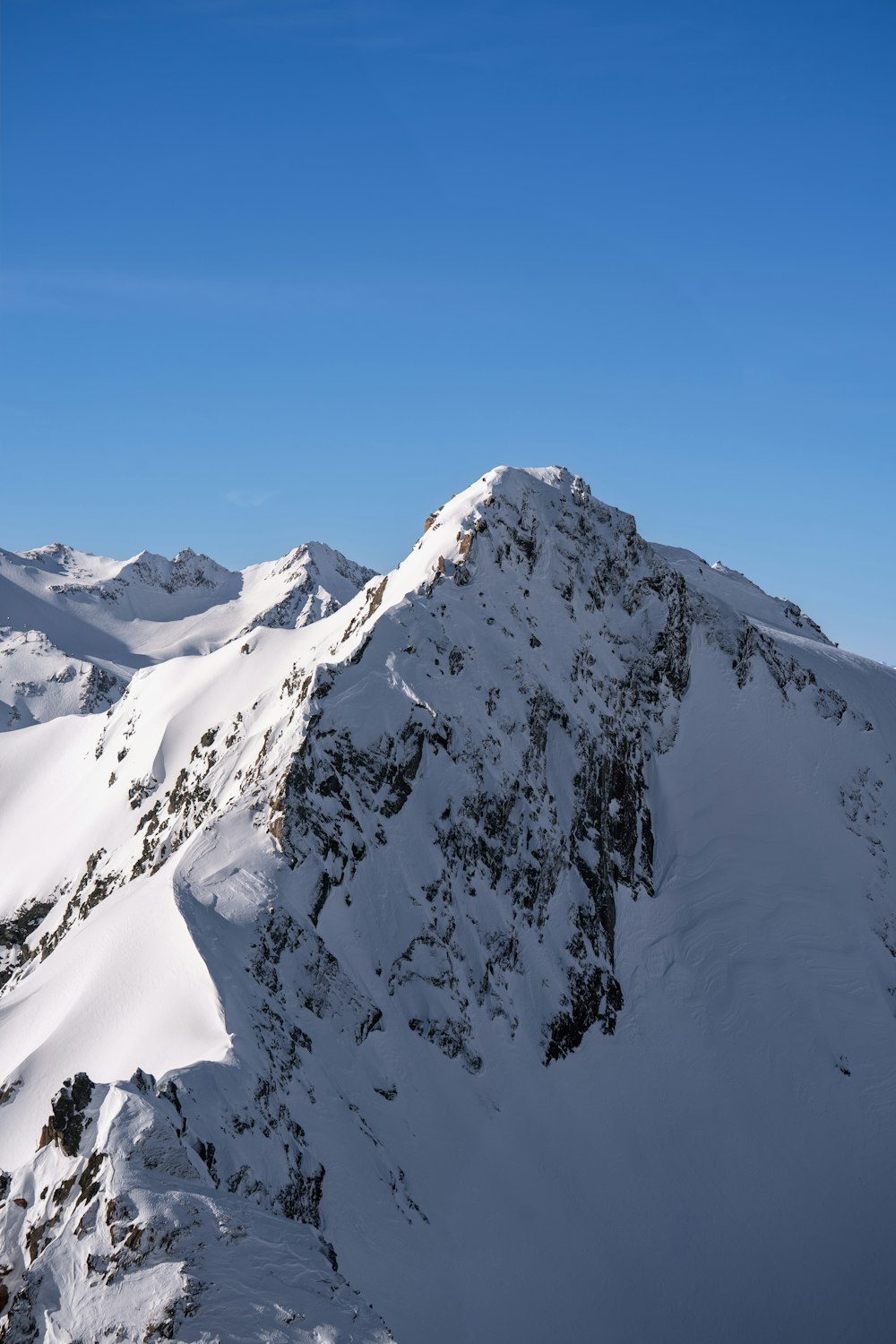 a mountain covered in snow under a blue sky