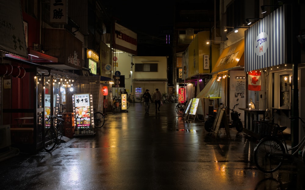 a dark alley at night with people walking around