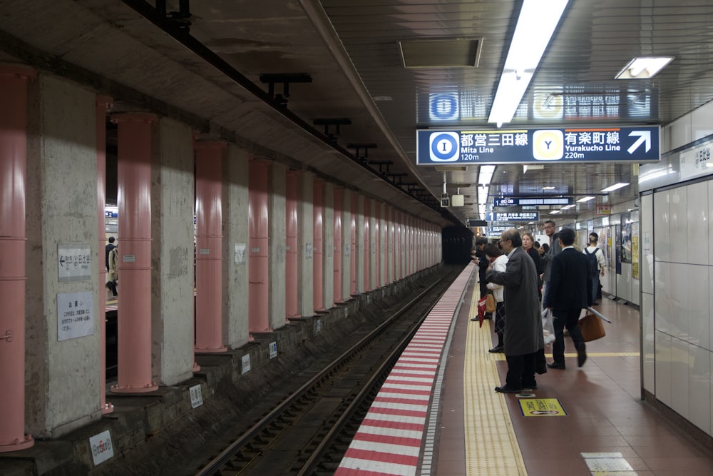 a group of people standing on a train platform