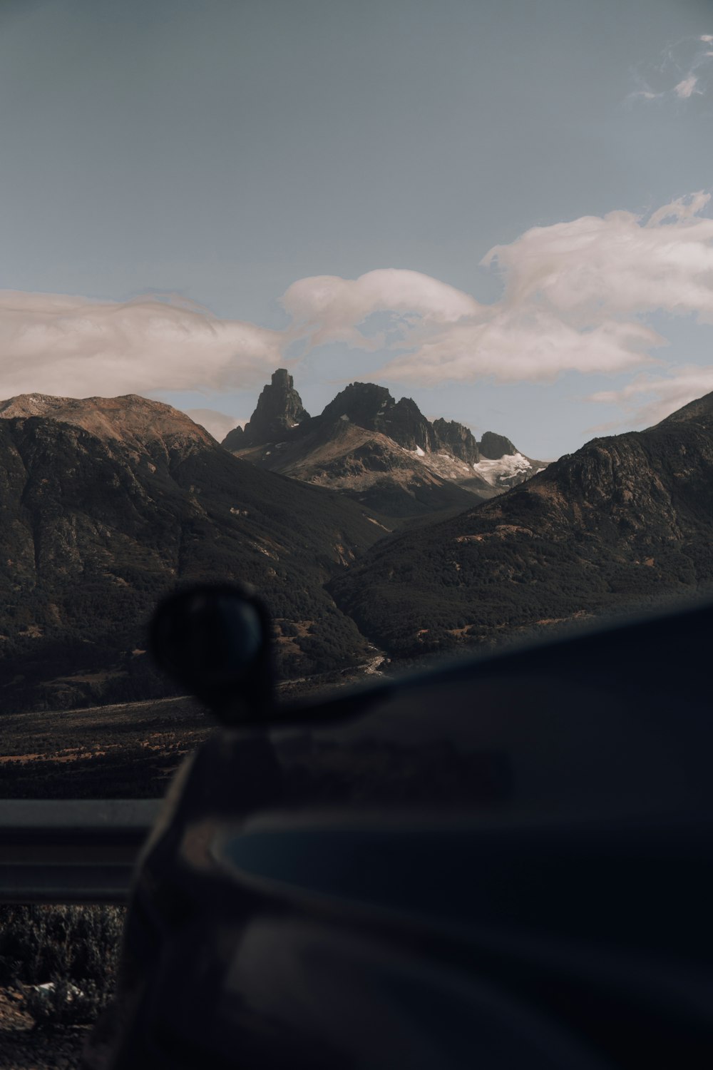 a car driving down a road in front of mountains
