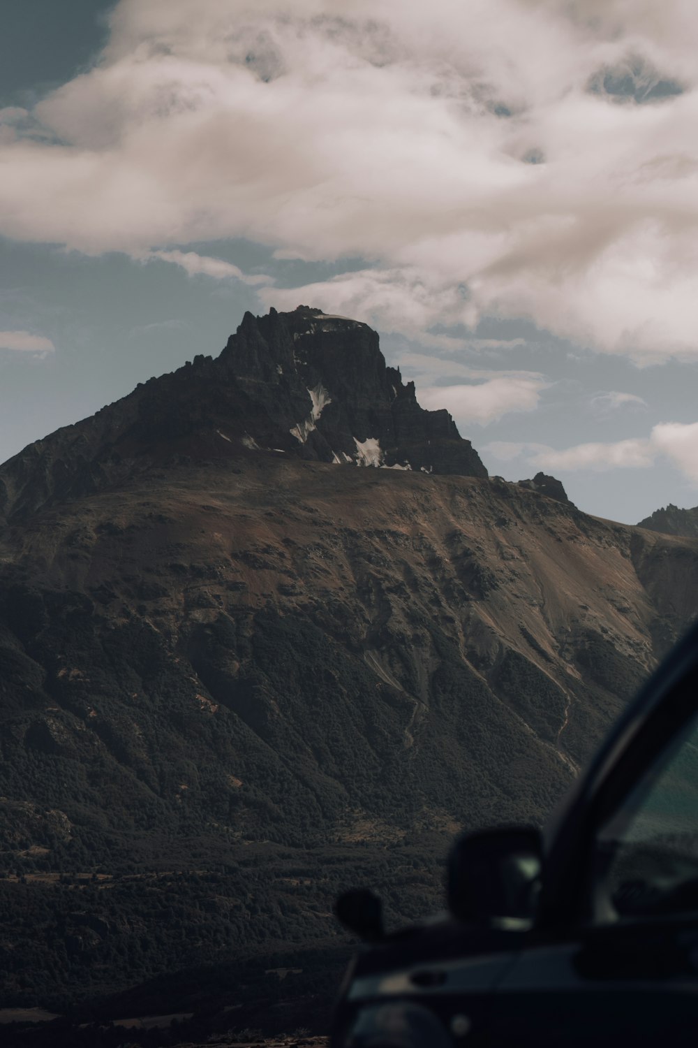 a car is parked in front of a mountain
