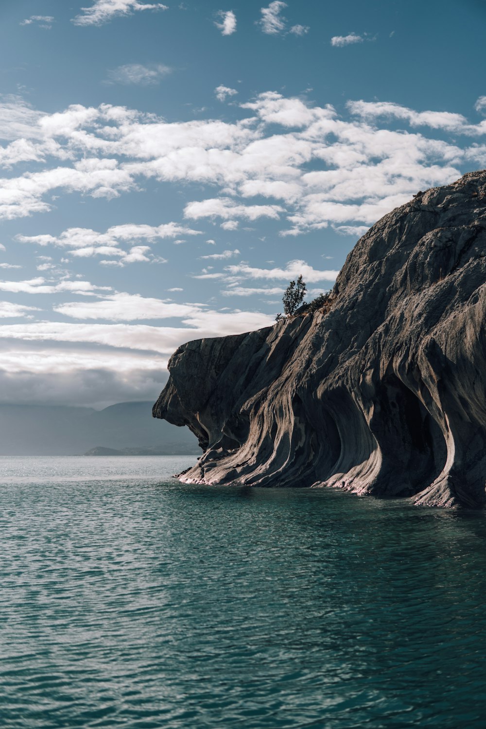 a large body of water sitting under a cloudy blue sky