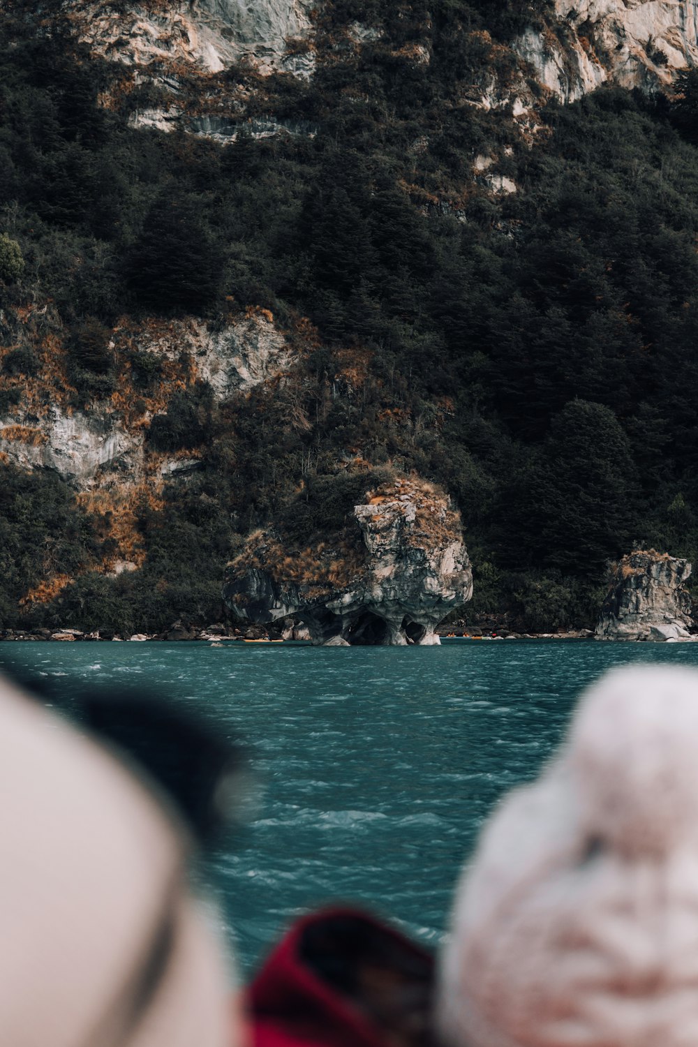 a boat traveling on a body of water near a mountain