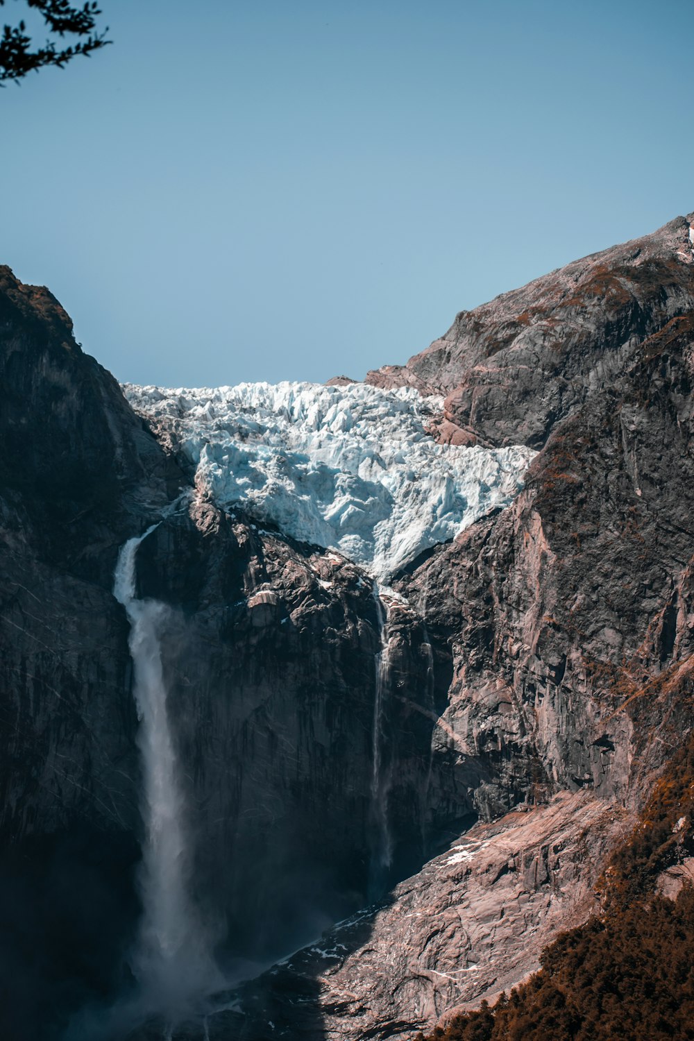 a very tall waterfall in the middle of a mountain