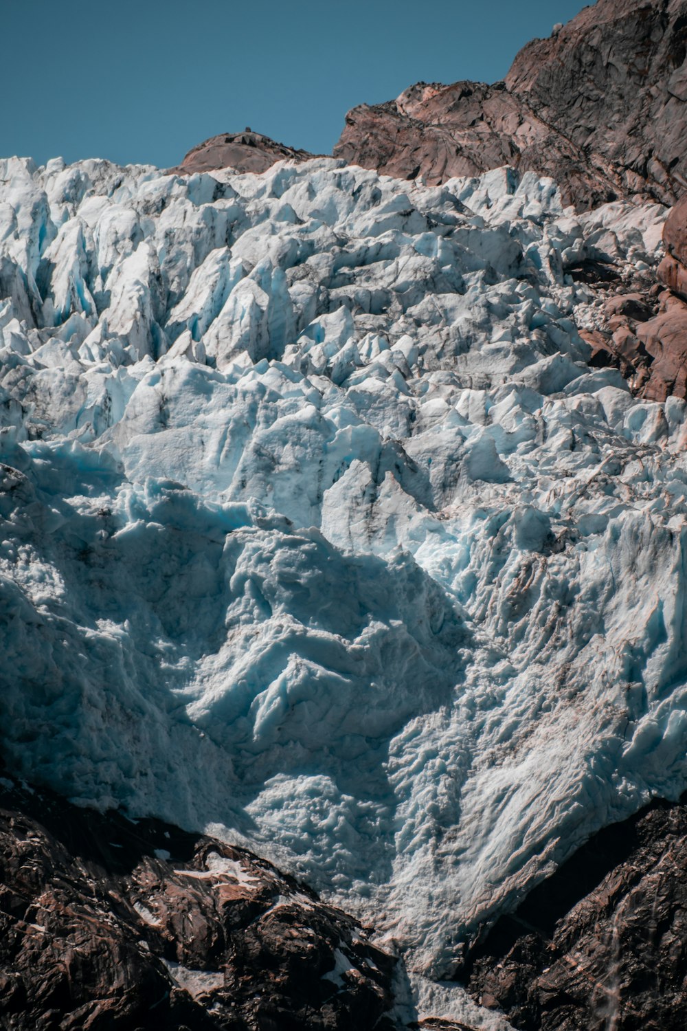 a very large glacier with some rocks and water