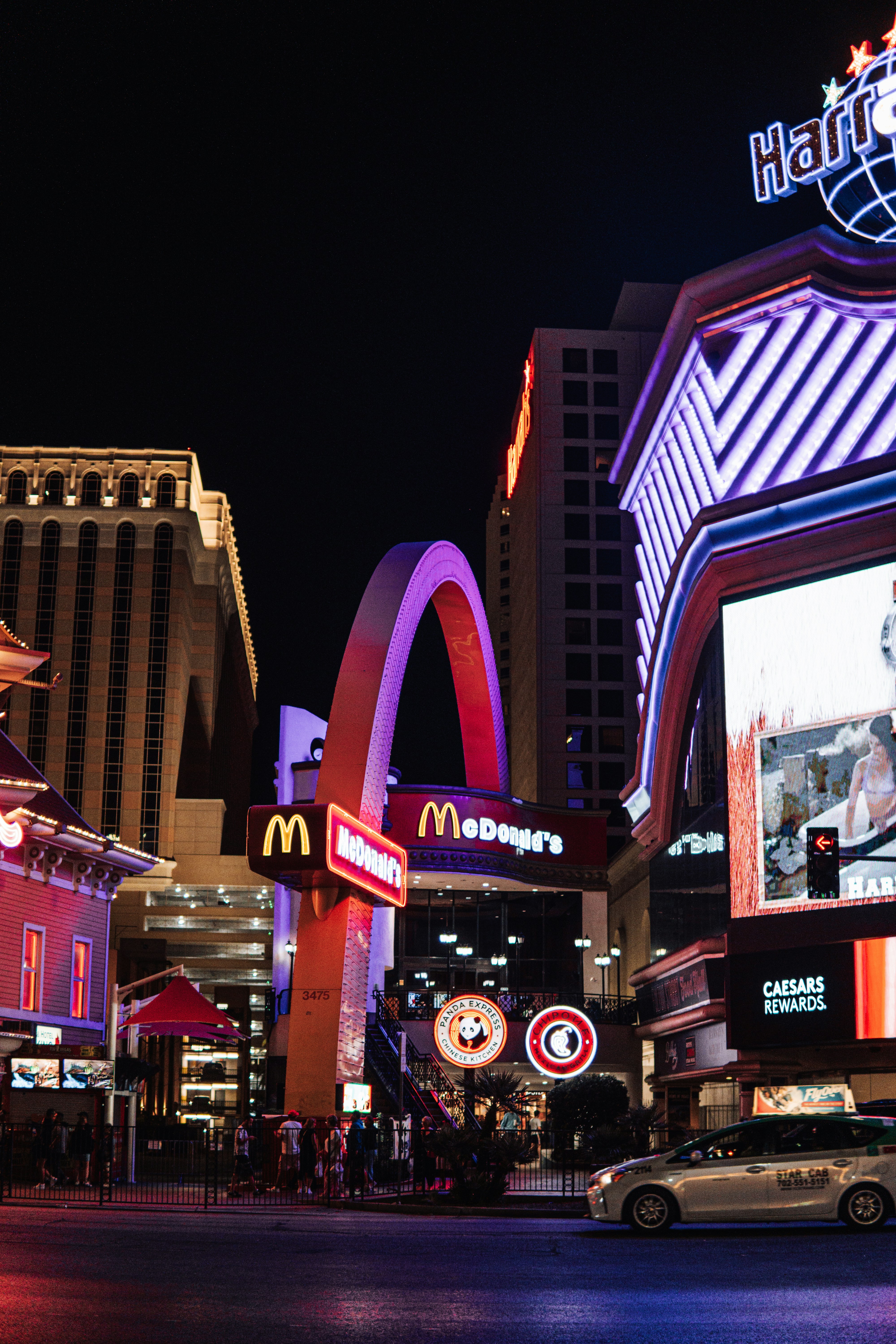 Una strada cittadina di notte con insegne al neon ed edifici