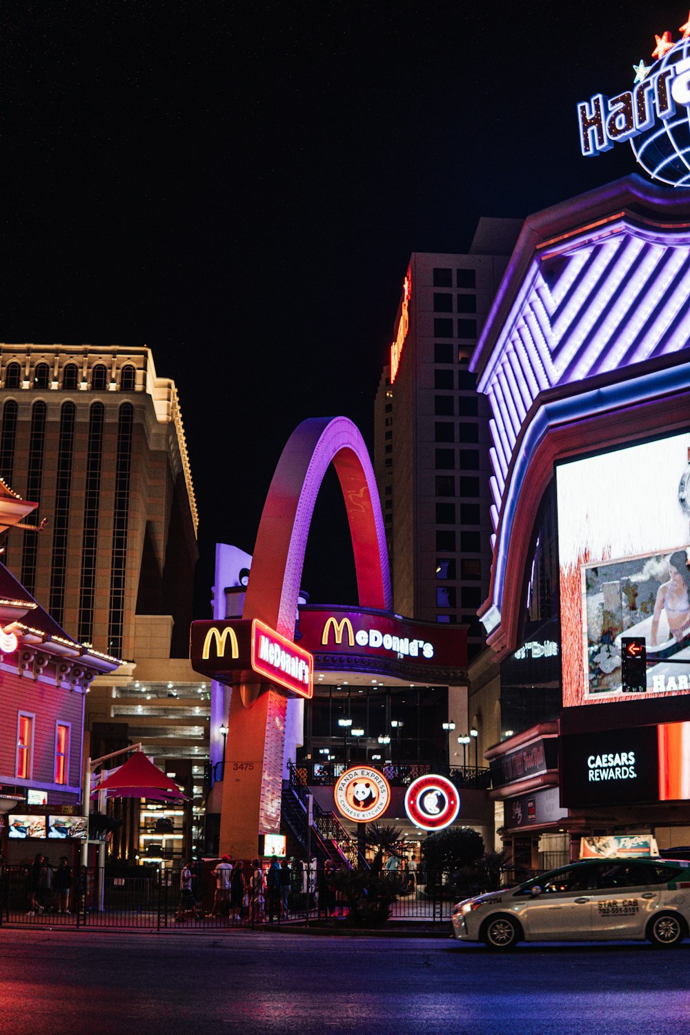 a city street at night with neon signs and buildings