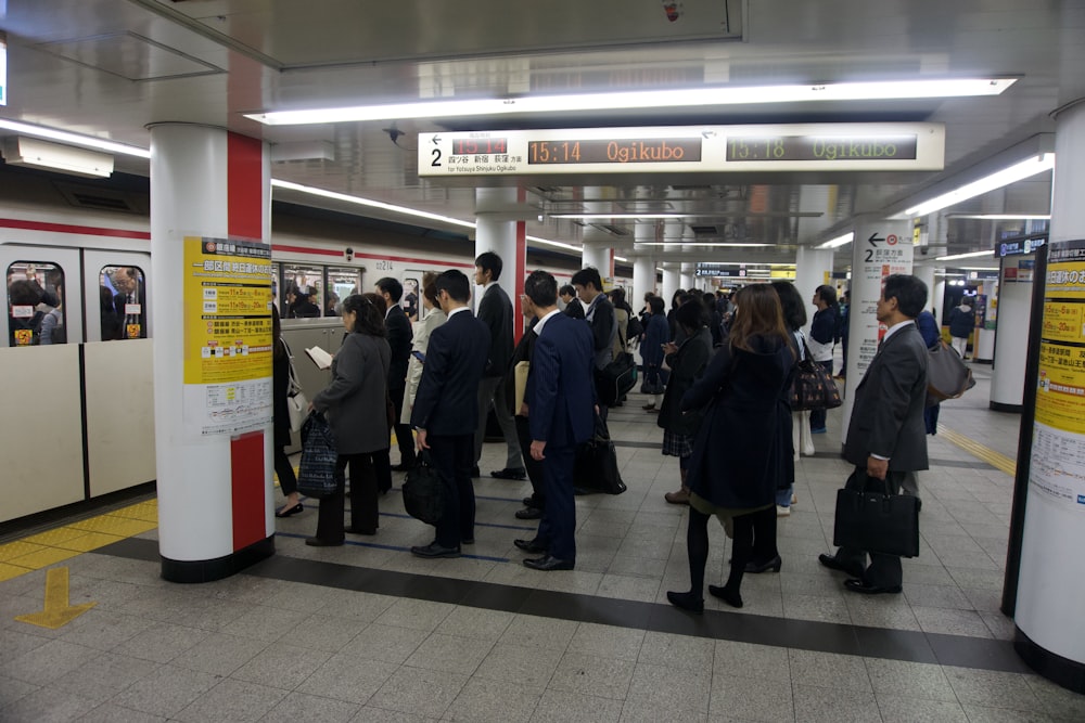 a group of people standing in a subway station