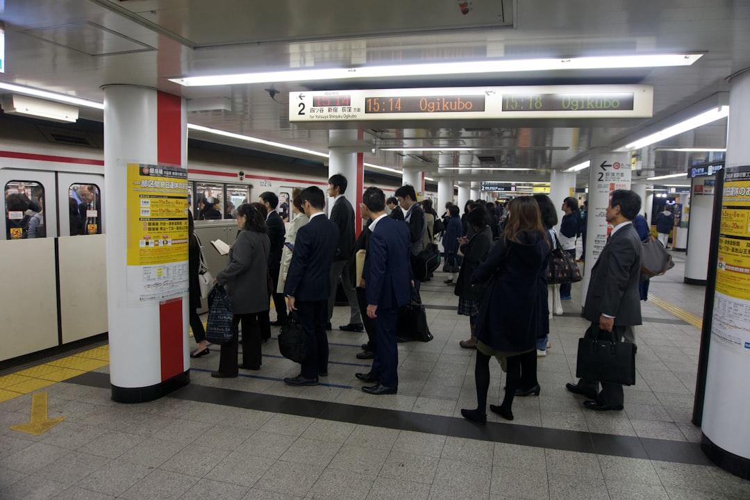 a group of people standing in a subway station,