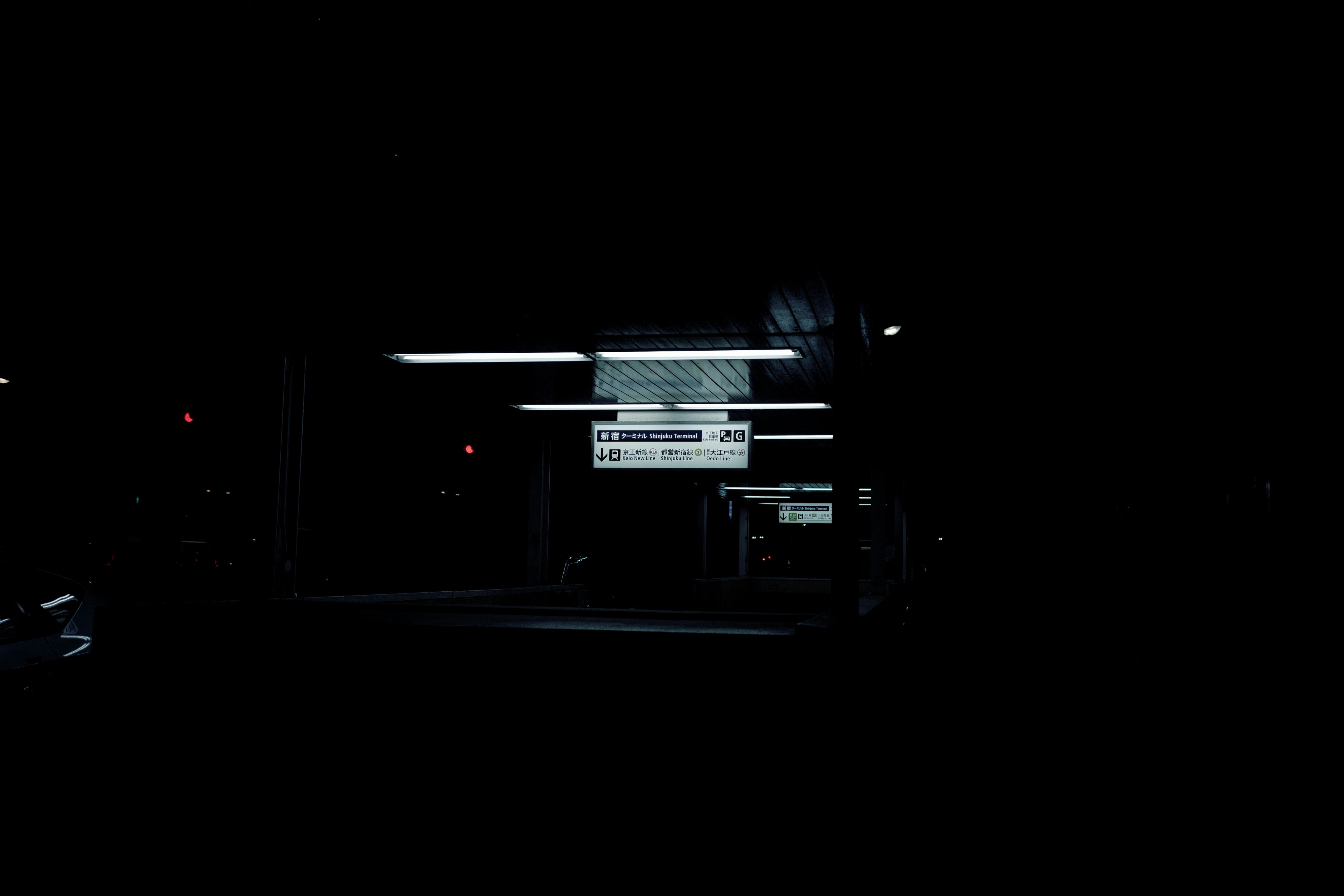 a bus stop at night with a sign lit up