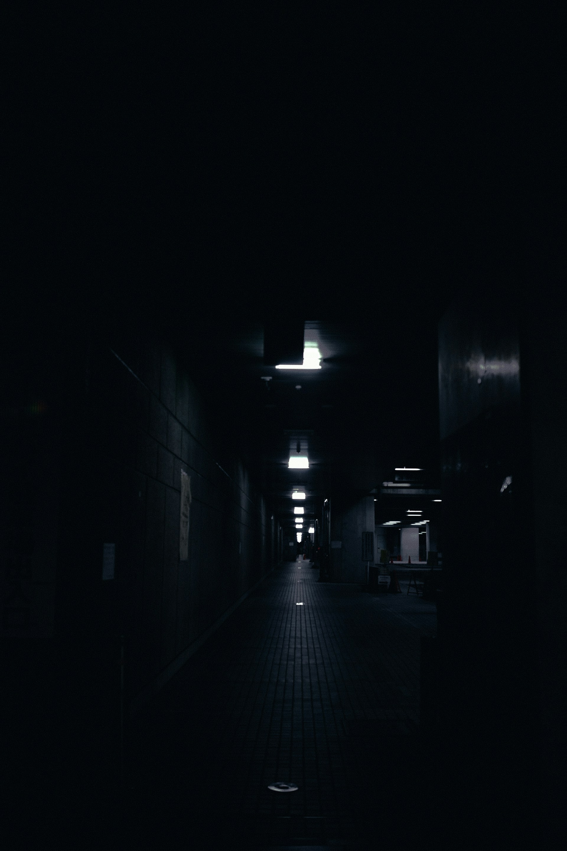 a dark hallway with a light at the end of it