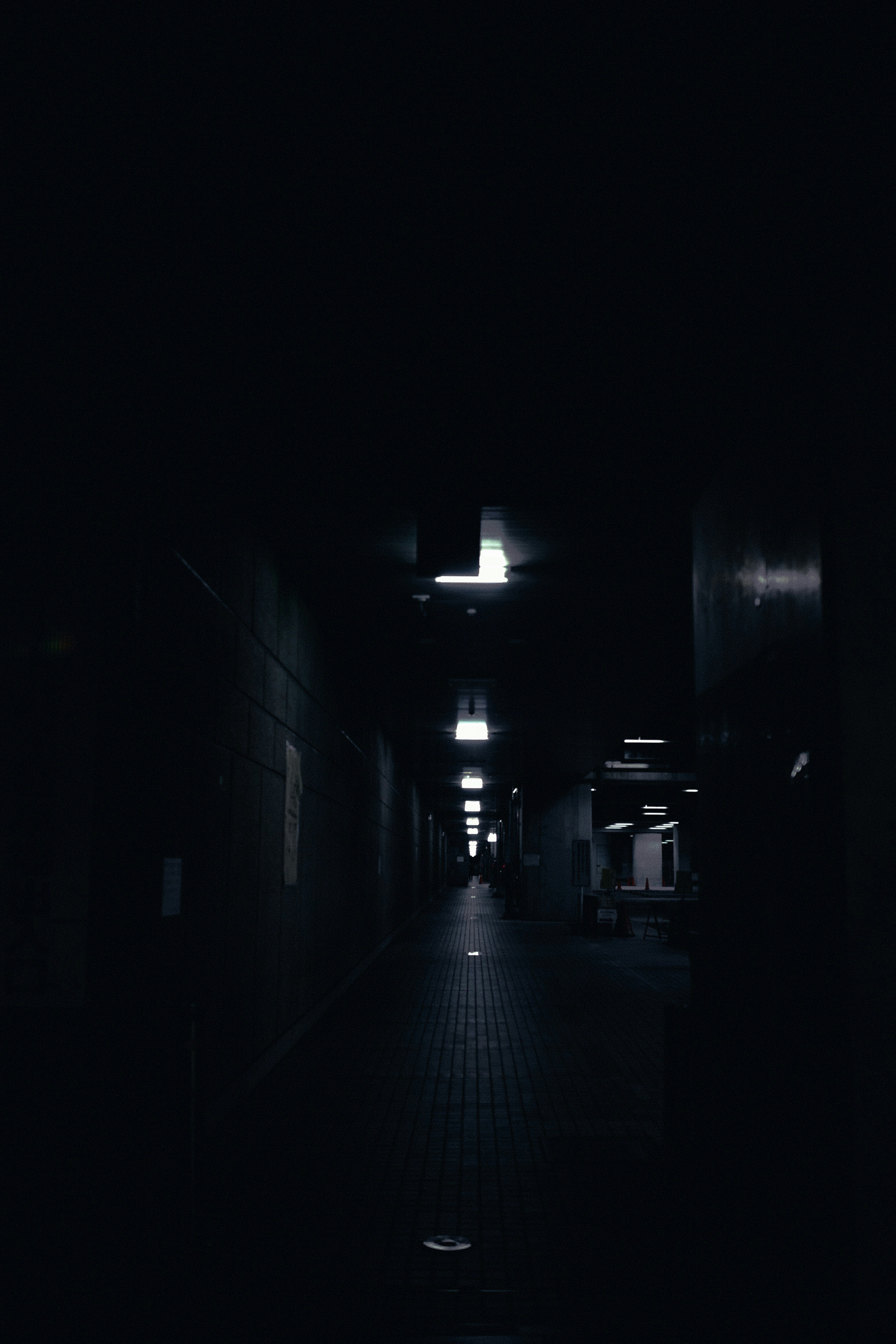 a dark hallway with a light at the end of it