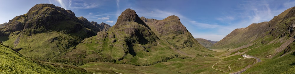 a wide view of a mountain range with a road going through it