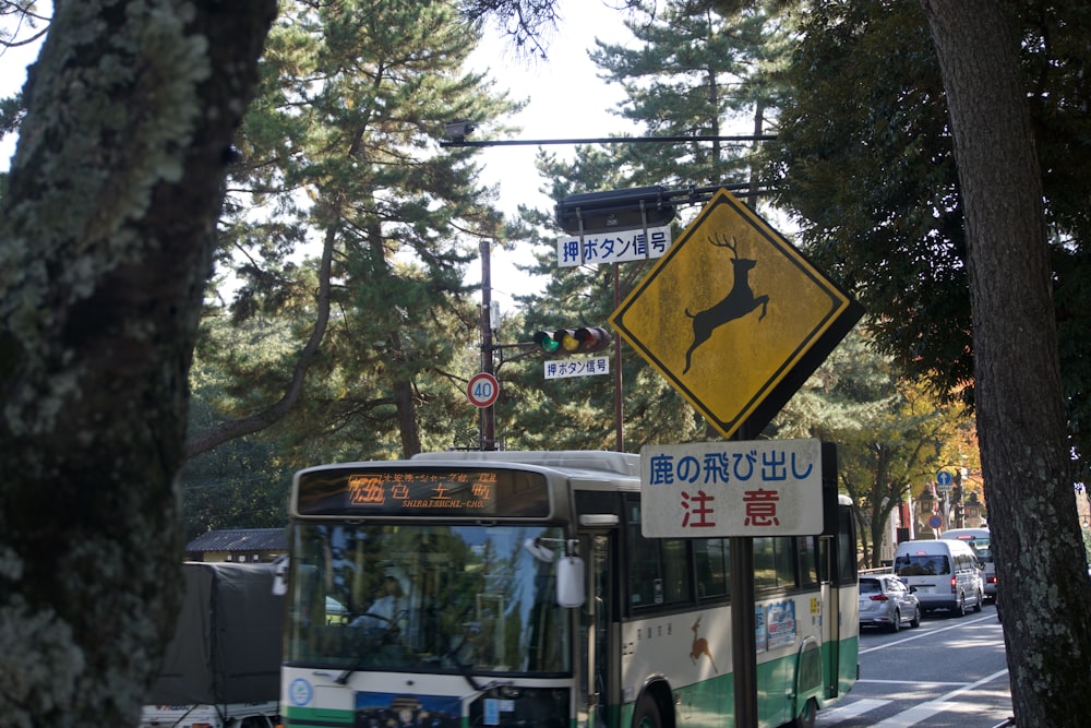 a bus driving down a street next to a forest