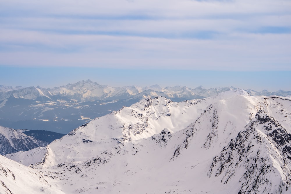 a view of a snowy mountain range with mountains in the background