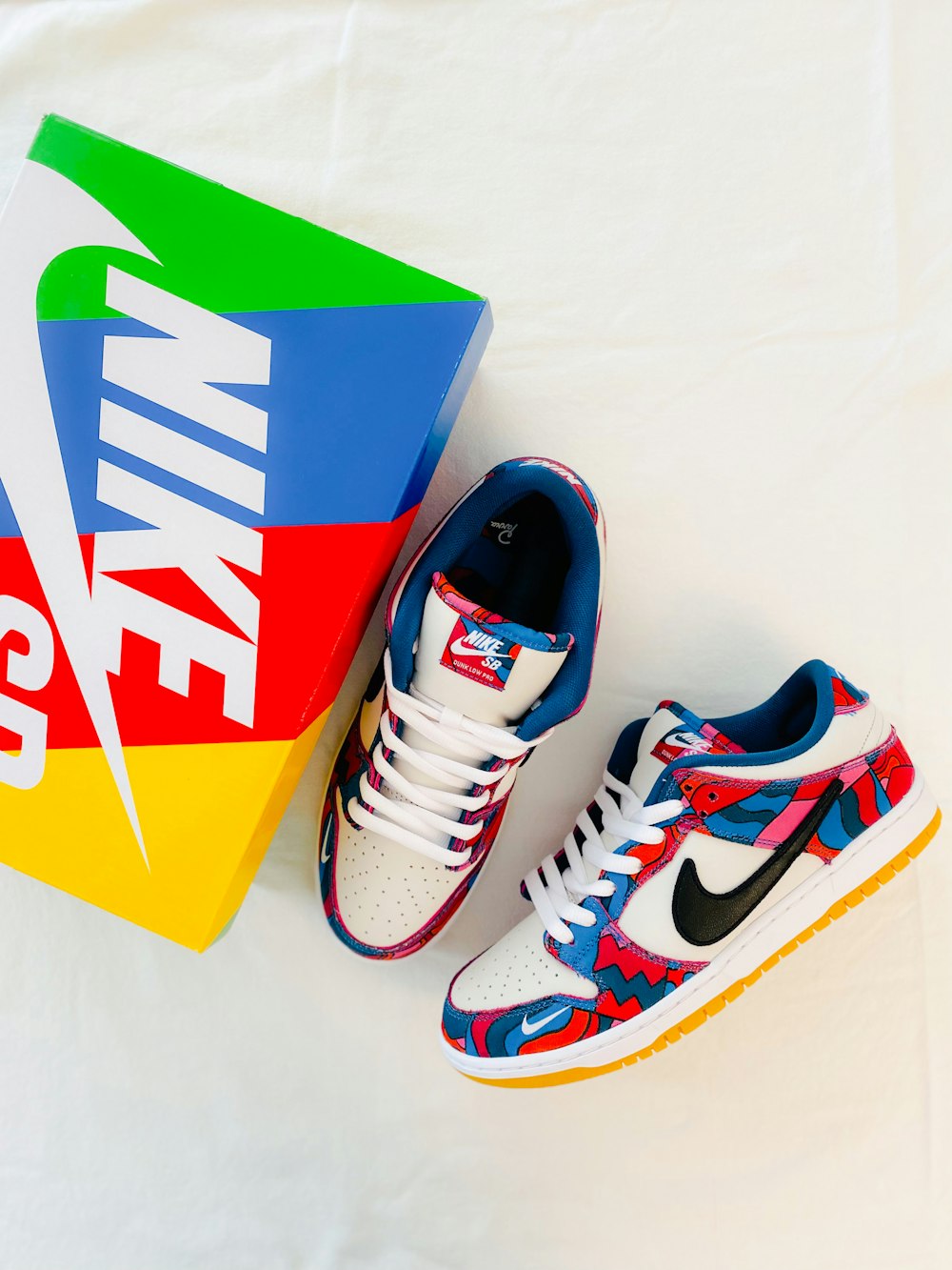 a pair of sneakers and a box on a white surface