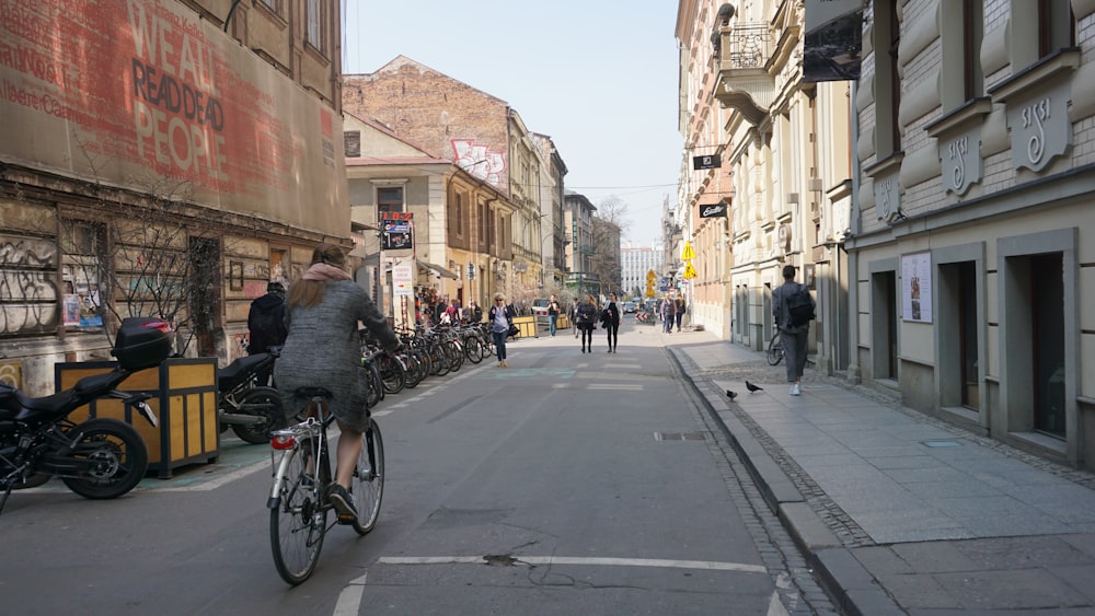 a man riding a bike down a street next to tall buildings