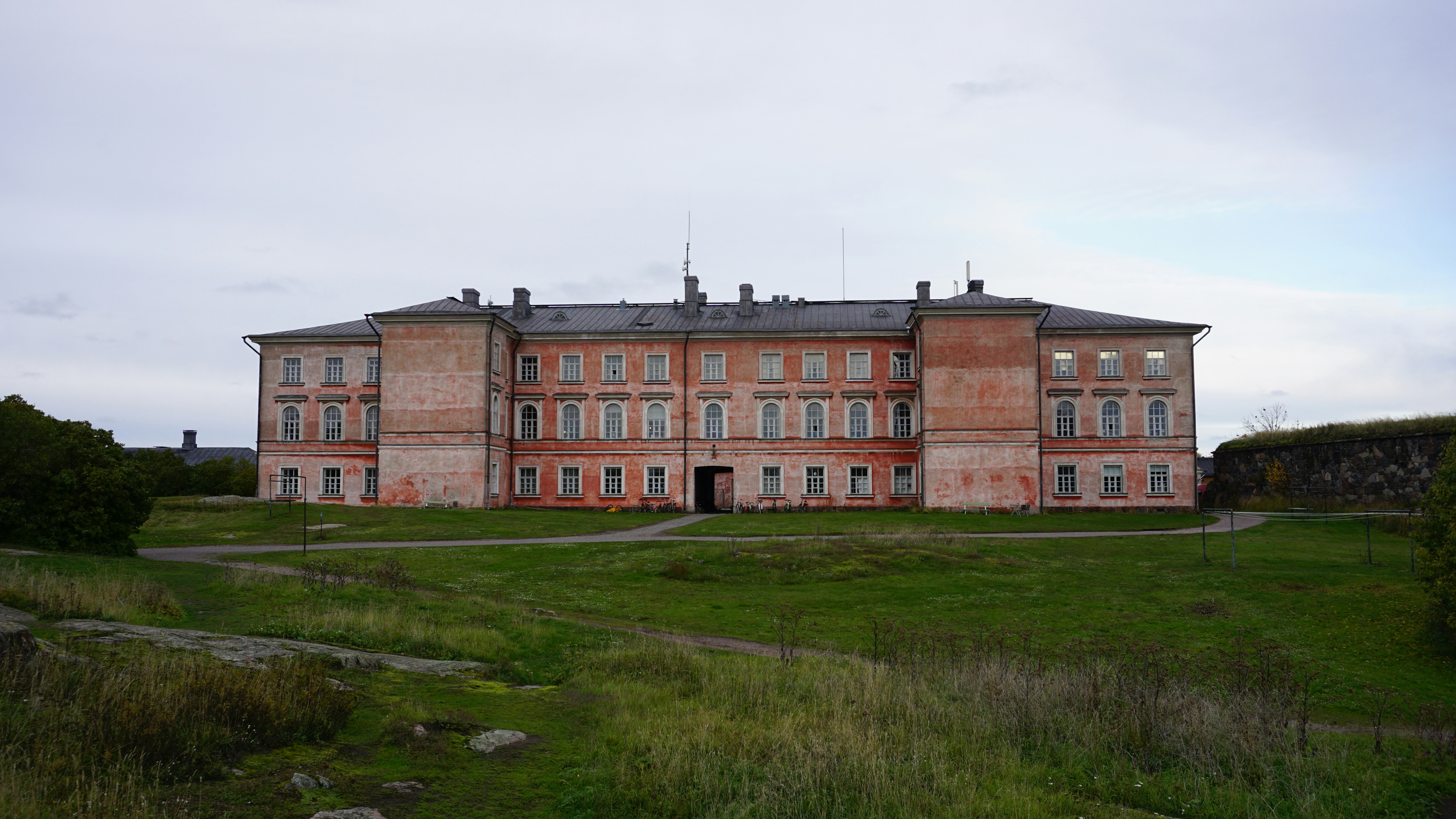 an old building with a grassy field in front of it