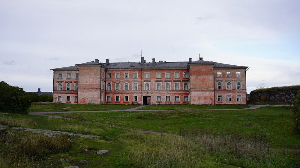 an old building with a grassy field in front of it