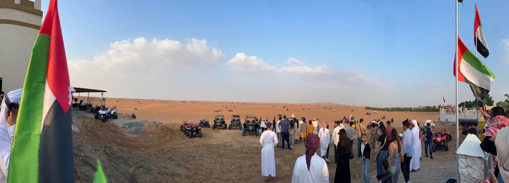 a group of people standing around a dirt field
